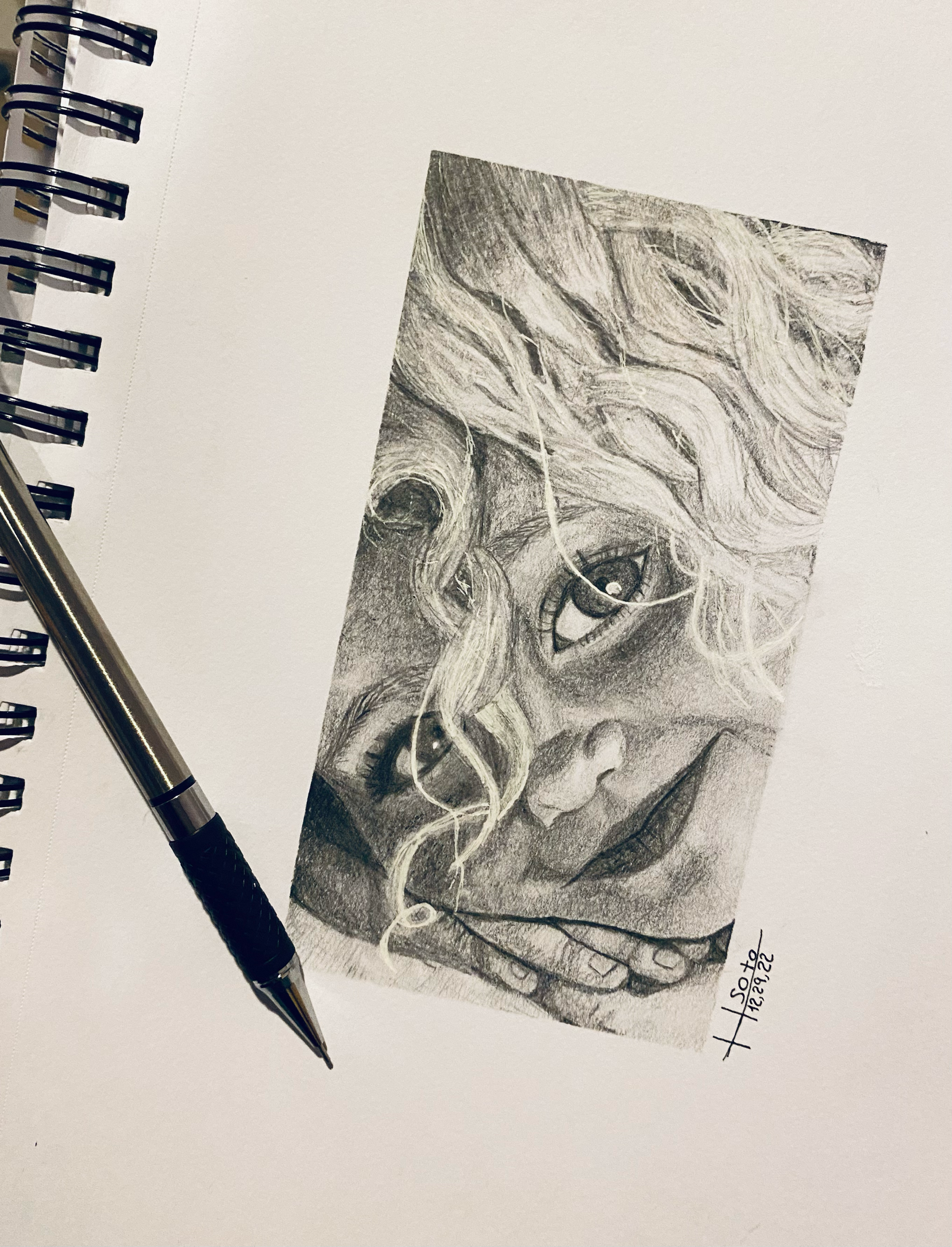  realilistic hand drawn black and white portrait of a young girl laying her head on her hands.